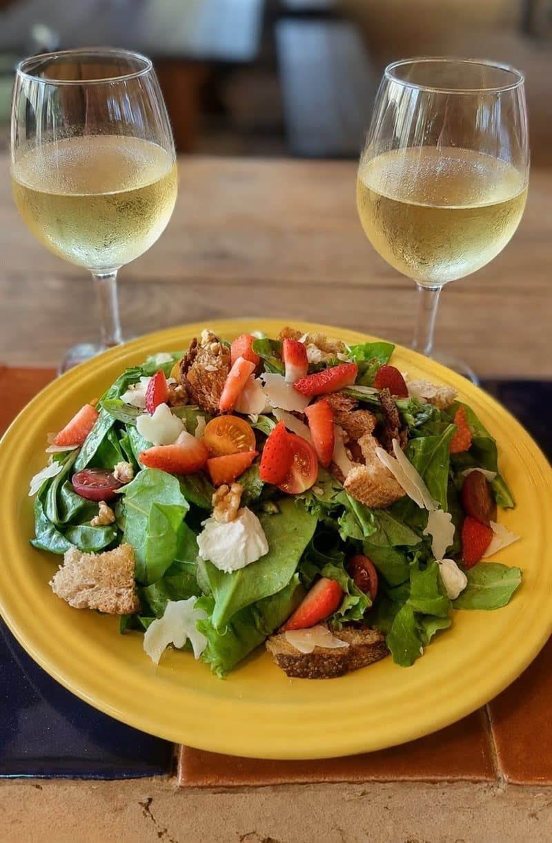 Green salad with strawberries and walnuts, with two glasses of white wine