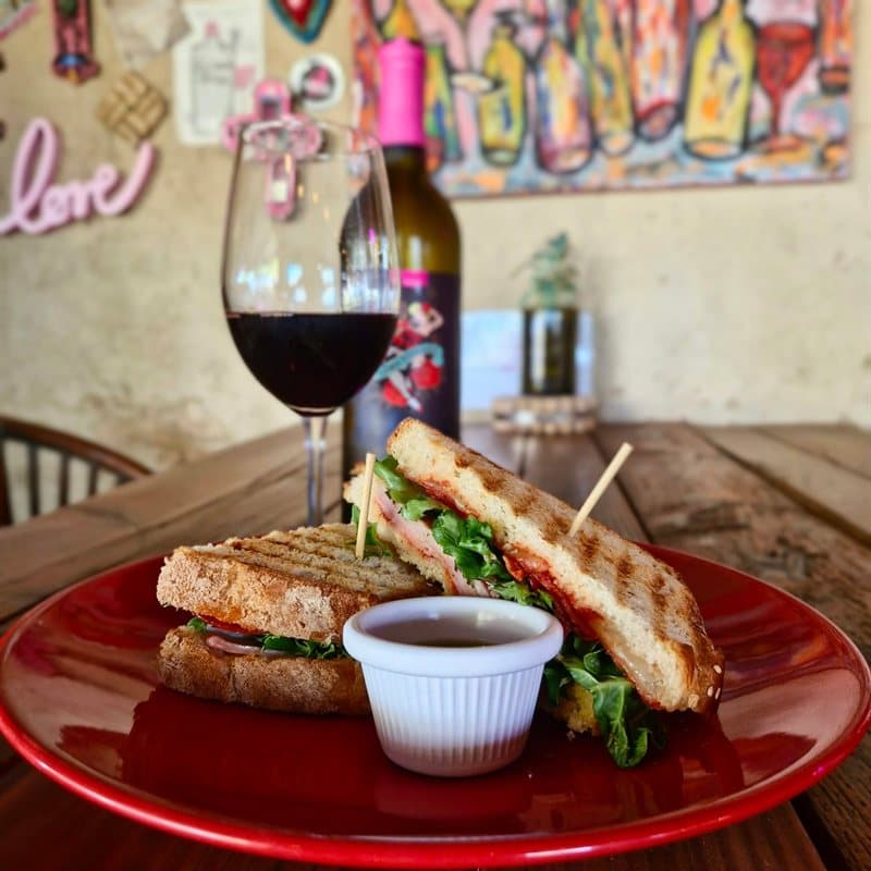 Grilled panini with a glass of red wine at El Corcho Rosa